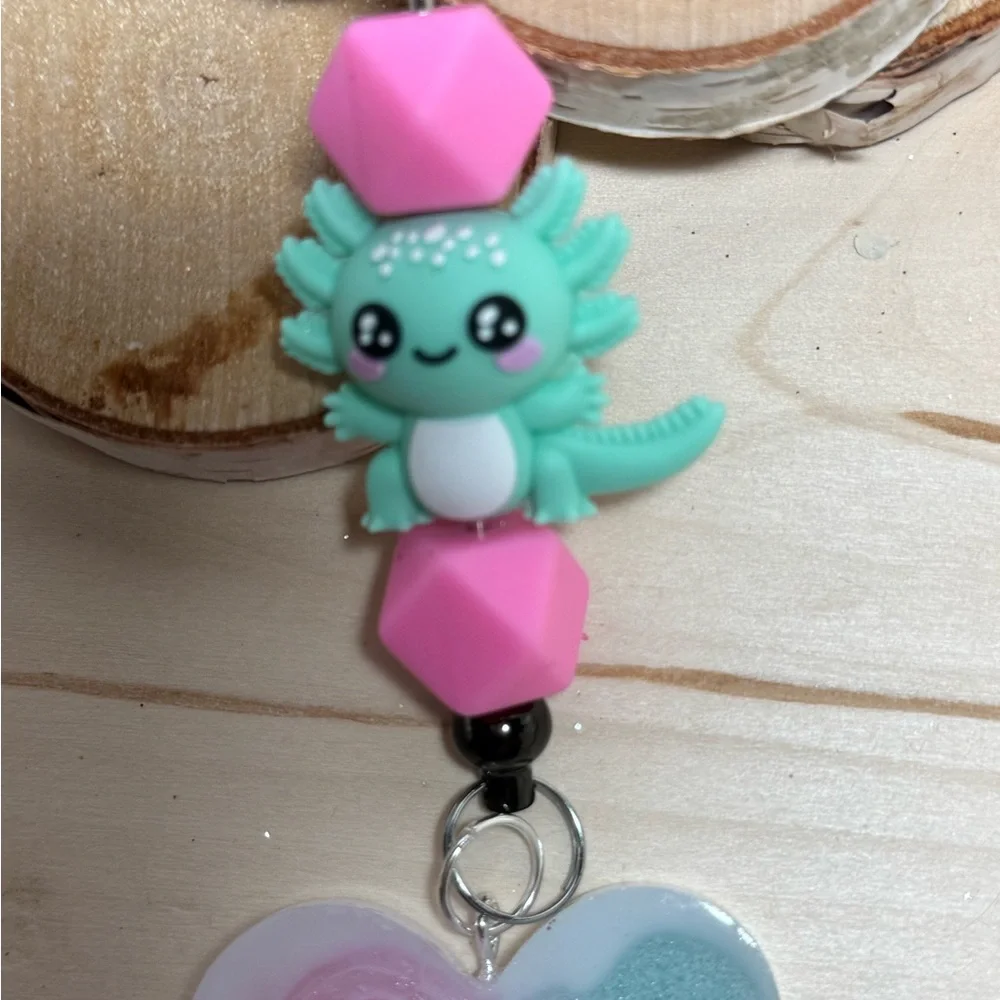 axolotl keychain with a pink and teal or blue resin heart pendant